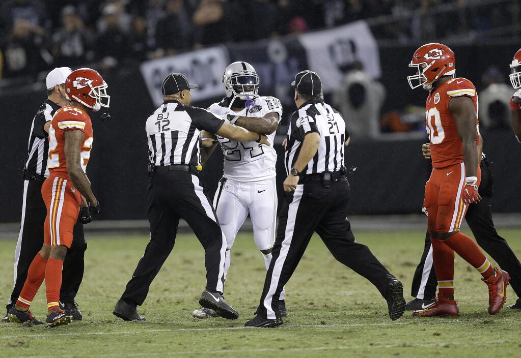 In this Oct. 19, 2017, file photo, Oakland Raiders running back Marshawn Lynch (24) makes contact with back judge Greg Steed (12) during the first half between the Raiders and the Kansas City Chiefs in Oakland. Lynch was ejected after the play. (AP Photo/Ben Margot, File)