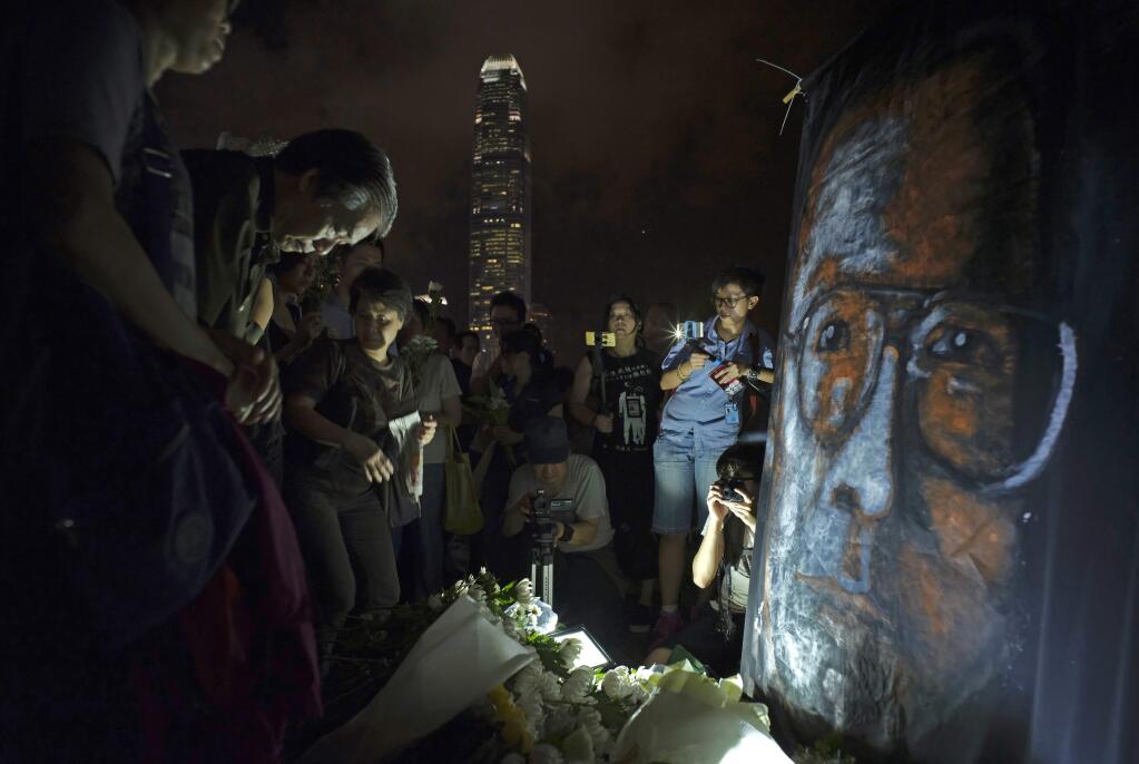 People pay tribute to late Chinese Nobel Peace laureate Liu Xiaobo on Wednesday at a park in Hong Kong. (VINCENT YU / Associated Press)