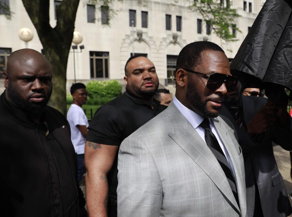 Musician R. Kelly, right, departs the Leighton Criminal Court building after pleading not guilty to 11 additional sex-related charges, Thursday, June 6, 2019, in Chicago. (AP Photo/Amr Alfiky)