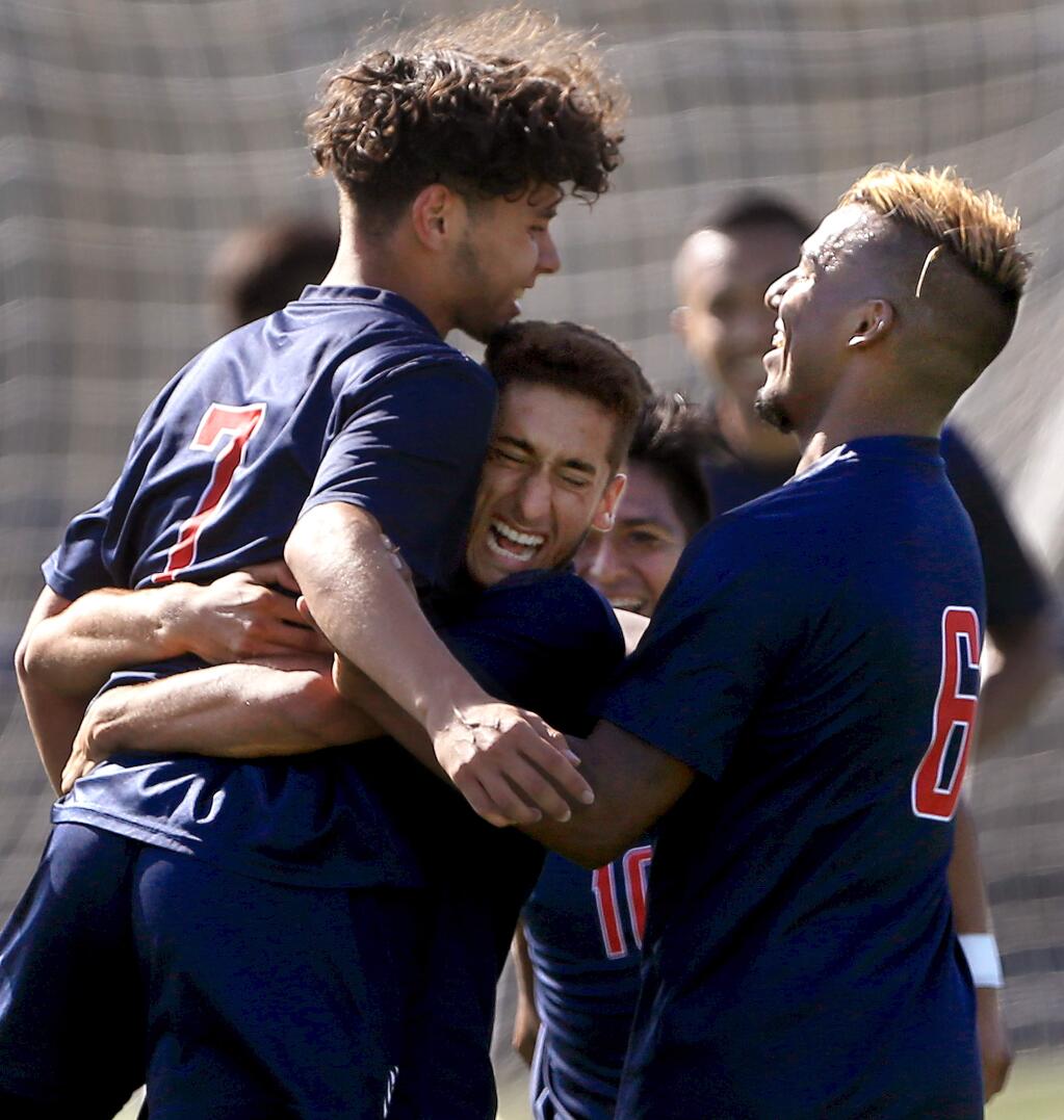 SRJC's Adrian Fontanelli, left, is congratulated by teammates Matias Gomez, middle, and Sergio Valenzuela after scoring the Bear Cubs' first goal within the first minute of play against the Contra Costa Comets, Wednesday, Sept. 4, 2019. (Kent Porter / The Press Democrat)