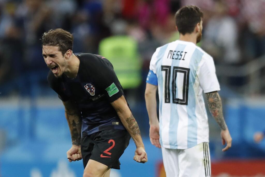 Argentina's Lionel Messi, right, leaves the pitch as Croatia's Sime Vrsaljko celebrates his team's 3-0 victory at the end of the Group D match between Argentina and Croatia at the World Cup in Nizhny Novgorod Stadium in Novgorod, Russia, Thursday, June 21, 2018. (AP Photo/Pavel Golovkin)