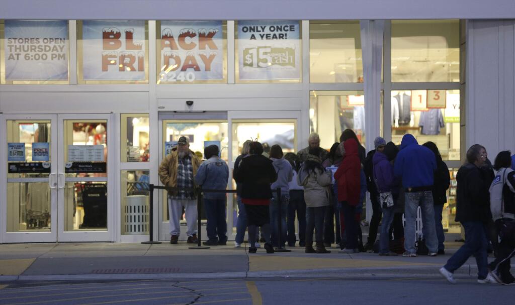 Holiday shoppers line up outside a Kohl's department store in Lawrence, Kan., Thursday, Nov. 27, 2014. The store opens at 6:00 Thanksgiving day. (AP Photo/Orlin Wagner)