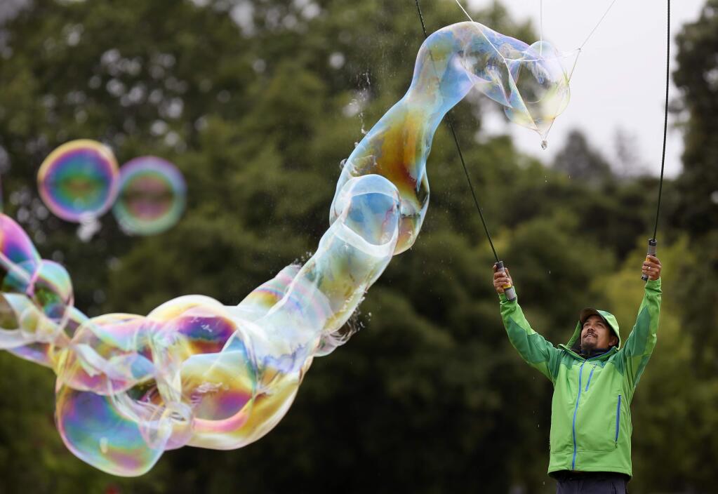 Chris Stephens makes a long trail of bubbles during the Larry Bertolini Day Under The Oaks at the Santa Rosa Junior College in Santa Rosa, on Sunday, May 3, 2015. (BETH SCHLANKER/ The Press Democrat)
