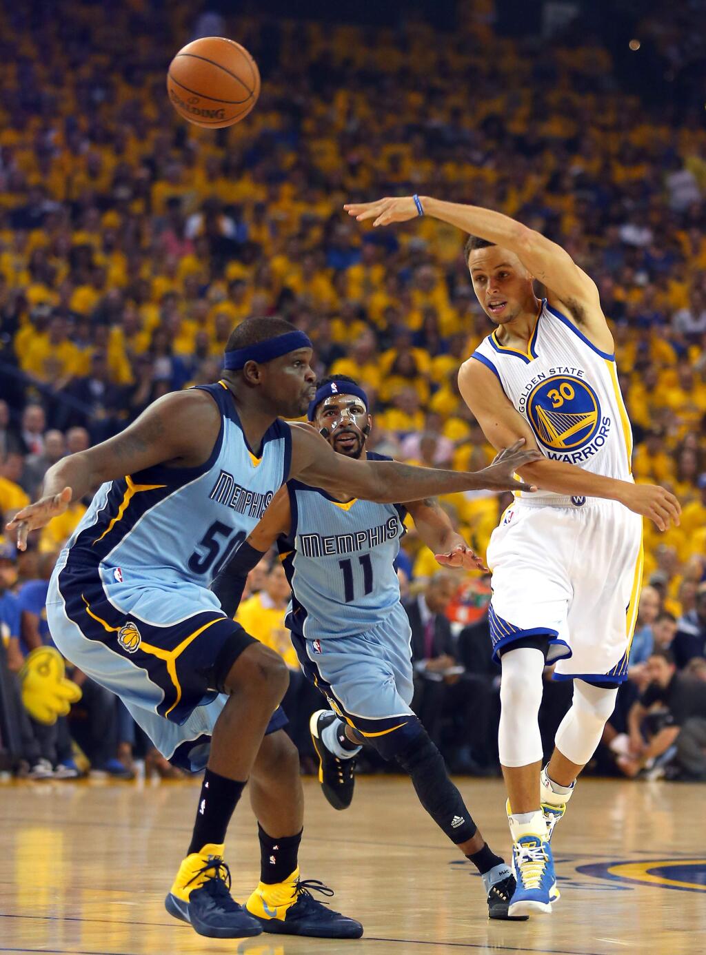 Golden State Warriors guard Stephen Curry passes the ball around Memphis Grizzlies forward Zach Randolph during Game 2 of the NBA Playoffs Western Conference Semifinals at Oracle Arena, in Oakland on Tuesday, May 5, 2015. (Christopher Chung/ The Press Democrat)