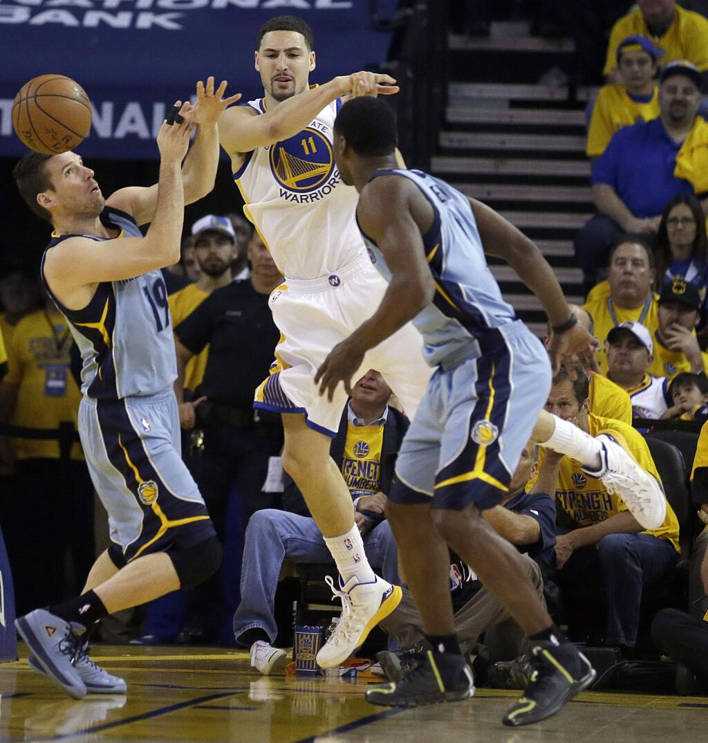 Golden State Warriors guard Klay Thompson (11) passes the ball between Memphis Grizzlies guard Beno Udrih (19) and forward Tony Allen during the first half of Game 2 in a second-round NBA playoff basketball series in Oakland, Calif., Tuesday, May 5, 2015. (AP Photo/Ben Margot)