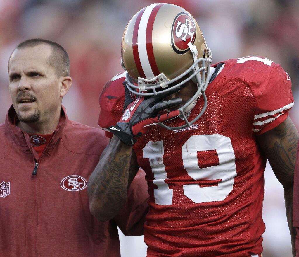 Ted Ginn Jr. is helped off the field after being injured in the third quarter of the 49ers' playoff game against the New Orleans Saints on Jan. 14, 2012. (Paul Sakuma / Associated Press)