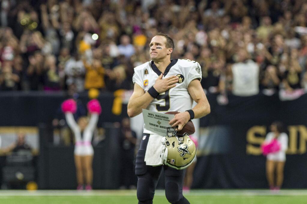 Drew Brees thanks the fans after breaking the NFL record for passing yards as The New Orleans Saints take on The Washington Redskins during Monday Night Football at the Mercedes-Benz Superdome in New Orleans, Monday, Oct. 8, 2018. (The Daily Advertiser via AP)