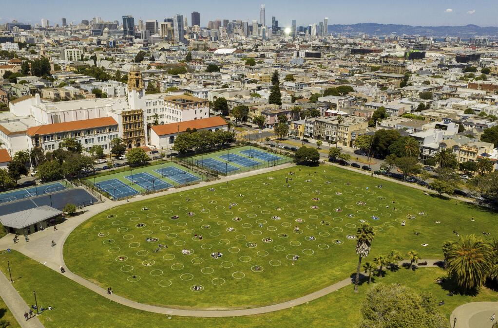Circles designed to help prevent the spread of the coronavirus by encouraging social distancing line San Francisco's Dolores Park, Thursday, May 21, 2020. (AP Photo/Noah Berger)