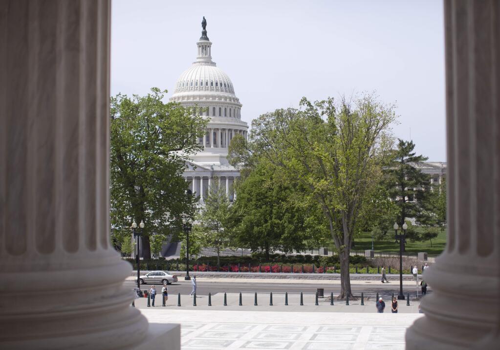 In this May 5, 2014, file photo, the U.S. Capitol building is seen through the columns on the steps of the Supreme Court in Washington. (AP Photo/Carolyn Kaster, File)