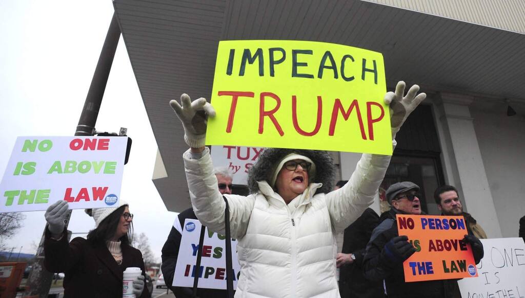 Anti supporter of President Donald Trump Rhonda Fallk, center, holds a sign at a protest rally Monday, Dec. 16, 2019, near Congressman Matt Cartrights Wilkes-Barre Field Office on Penn Place in Wilkes Barre, PA. (Mark Moran/AP)