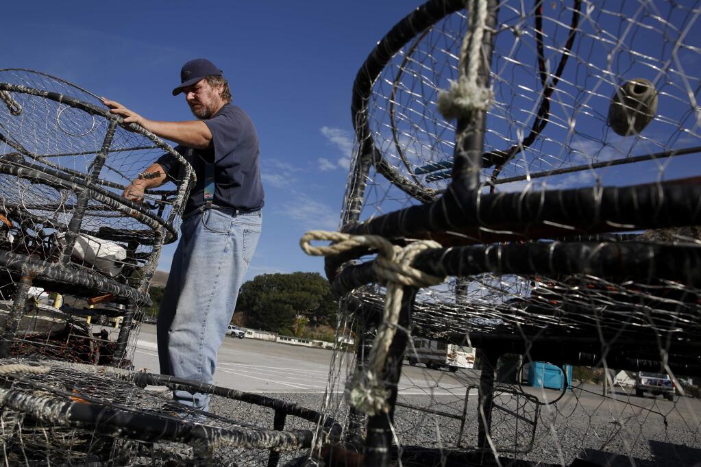 Alex Orsini prepares crab pots for the Miss Anita, a charter fishing boat, on Thursday, October 30, 2014 in Bodega Bay, California . (BETH SCHLANKER/ The Press Democrat)