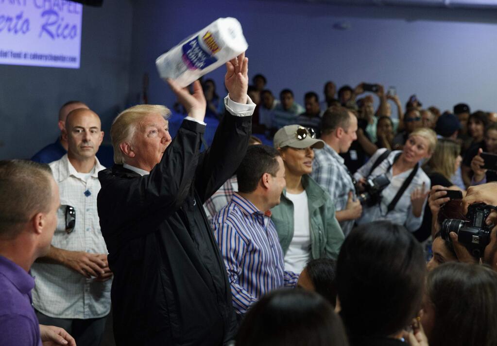 President Donald Trump tosses paper towels into a crowd in Guaynabo, Puerto Rico. (EVAN VUCCI / Associated Press)