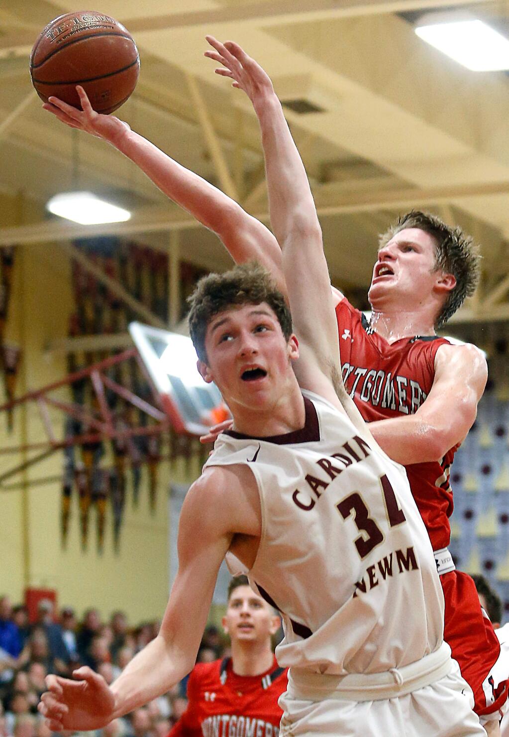 Montgomery's Evan Poulsen (5), right, goes for a layup over Cardinal Newman's Nathan Capurro (34) during the first half of a boys varsity basketball game between Montgomery and Cardinal Newman high schools, in Santa Rosa, California, on Tuesday, January 30, 2018. (Alvin Jornada / The Press Democrat)