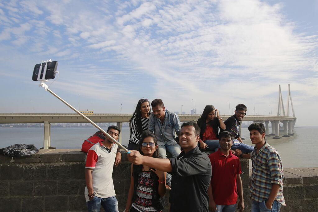 In this Feb. 22, 2016, photo, Indians take a selfie on Mumbai's coastline. (AP Photo/Rafiq Maqbool)