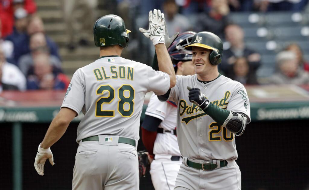 The Oakland Athletics' Mark Canha is congratulated by Matt Olson after Canha hit a two-run home run off Cleveland Indians starting pitcher Trevor Bauer in the third inning Tuesday, May 21, 2019, in Cleveland. Olson scored on the play. (AP Photo/Tony Dejak)