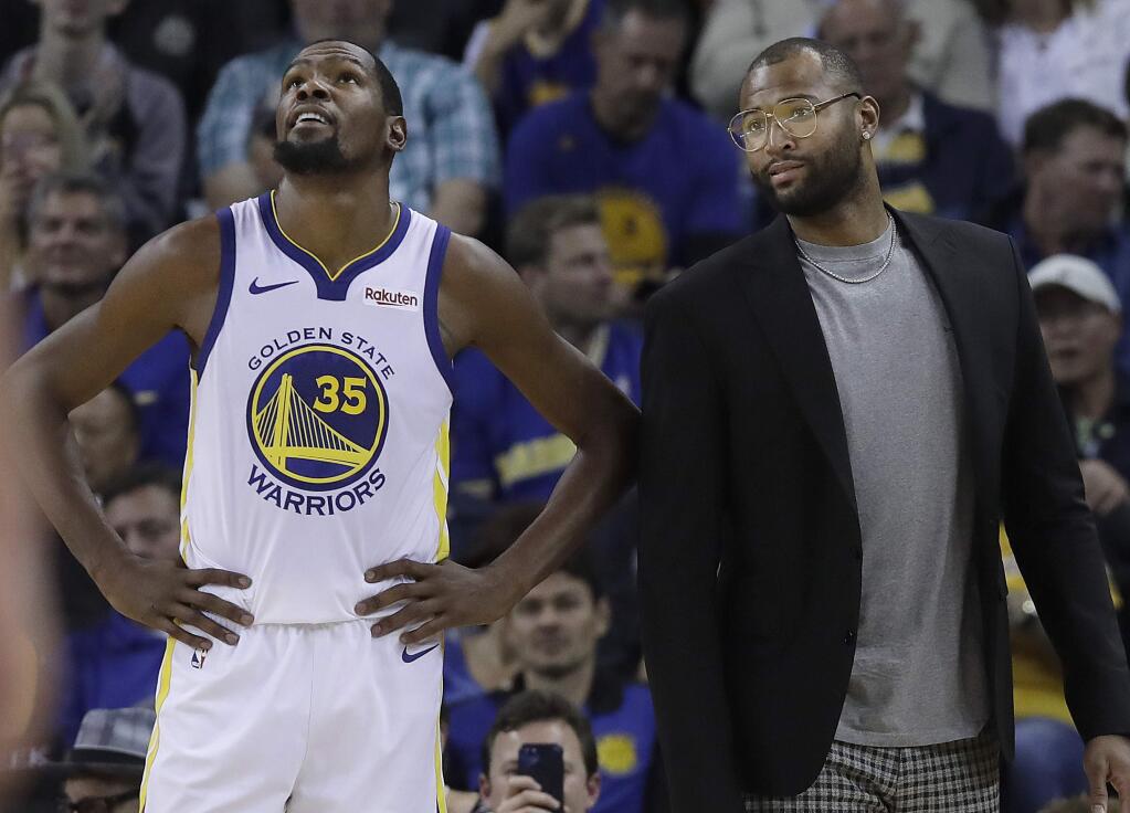 Golden State Warriors forward Kevin Durant, left, stands on the sideline with DeMarcus Cousins during the second half against the Phoenix Suns in Oakland, Monday, Oct. 22, 2018. (AP Photo/Jeff Chiu)