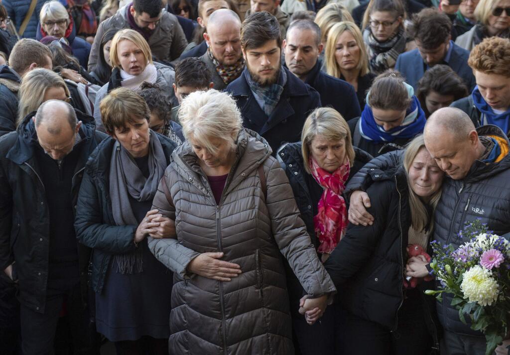 The family of Jack Merritt take part in a vigil at The Guildhall to honour him and Saskia Jones who were both killed in Friday's attack on London Bridge, in Cambridge, England, Monday, Dec. 2, 2019. London Bridge reopened to cars and pedestrians Monday, three days after a man previously convicted of terrorism offenses stabbed two people to death and injured three others before being shot dead by police. (Joe Giddens/PA via AP)