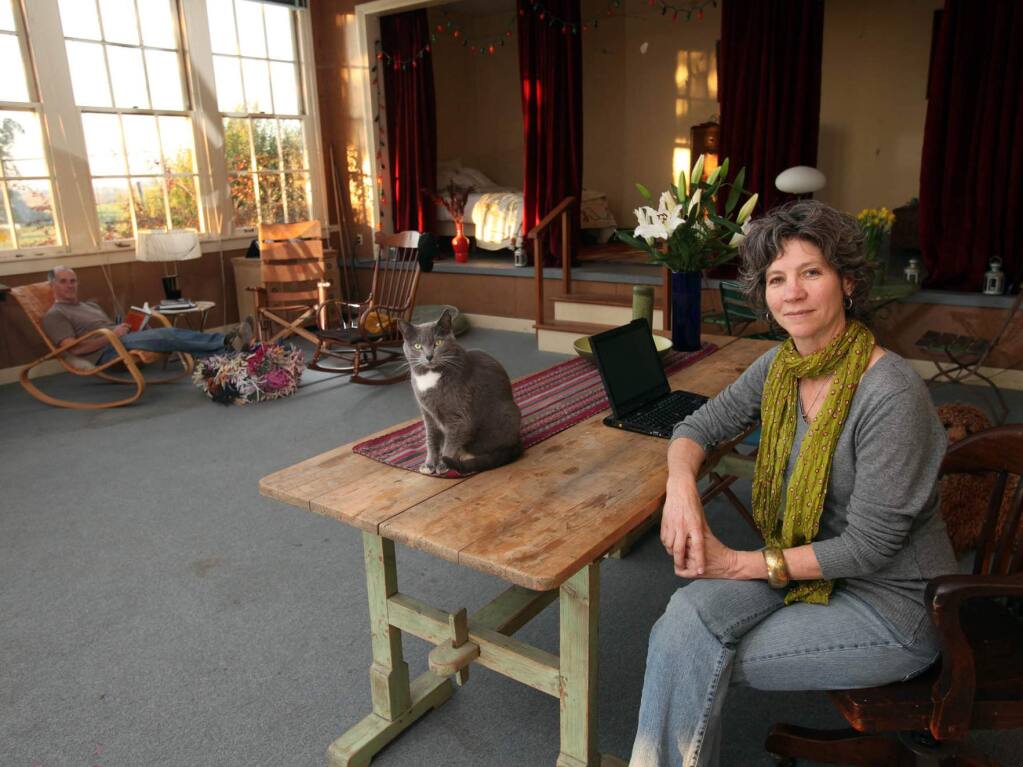 Cinda Gilliland sits at her desk with her cat Misty at the Waugh School in Petaluma. Gilliland and her husband, Lawrence Reed, converted Depression-era construction to a private residence. (CRISTA JEREMIASON/ THE PRESS DEMOCRAT)