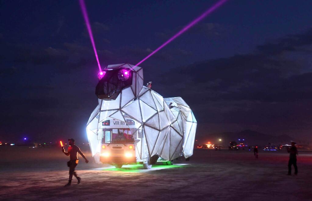 In this Sunday night, Aug. 23, 2014 photo, an art car is driven to the Black Rock DMV to be registered at the annual Burning Man event on the Black Rock Desert of Gerlach, Nev. (AP Photo/Reno Gazette-Journal, Andy Barron)