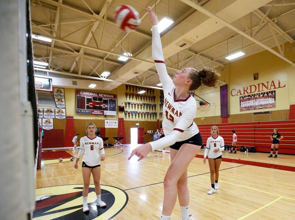 Cardinal Newman outside hitter Cassie Taylor puts down a kill, while her teammates Kimi Waller, left, and Cameron Loxley look on, during practice at Cardinal Newman High School on Tuesday, Aug. 27, 2019. (Alvin Jornada / The Press Democrat)