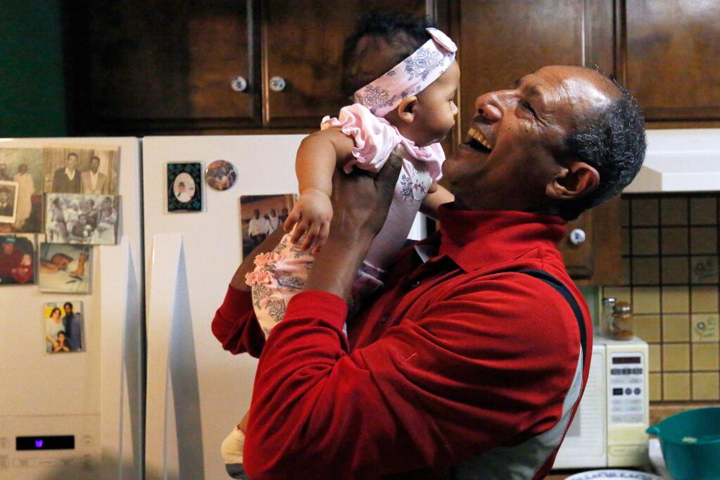 Girmai Araya plays with his 5-month-old granddaughter Elizabeth Sikes at his home in Santa Rosa, California on Wednesday, November 25, 2015. (Alvin Jornada / The Press Democrat)