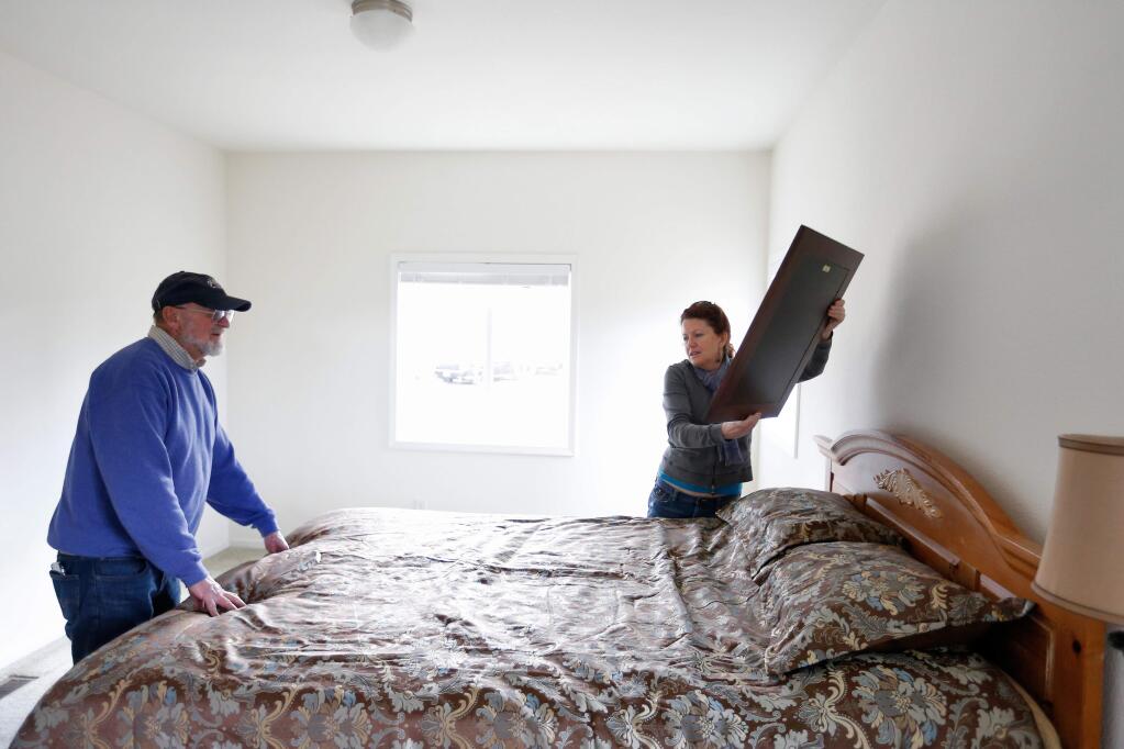 Jim Westrich, left, and his daughter Shawna Walker hang pictures in the bedroom of his new home in Middletown, California, on Saturday, January 30, 2016. Westrich is the first Middletown homeowner to rebuild in the aftermath of the Valley Fire. (Alvin Jornada / The Press Democrat)