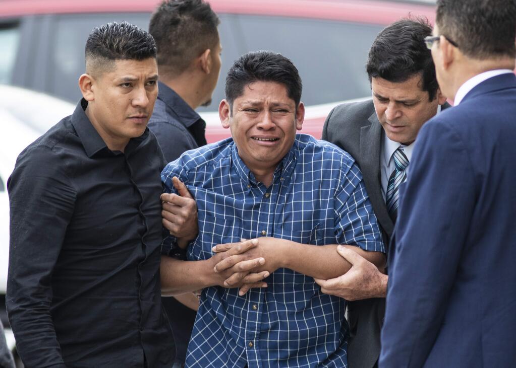 Arnulfo Ochoa, the father of Marlen Ochoa-Lopez, is surrounded by family members and supporters, as he walks into the Cook County medical examiner's office to identify his daughter's body, Thursday, May 16, 2019 in Chicago. (Ashlee Rezin/Chicago Sun-Times via AP)