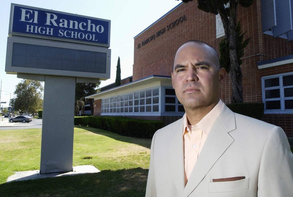 In this July 21, 2010, photo, teacher Gregory Salcido stands in front of El Rancho High School in Pico Rivera, Calif., after a complaint has been filed against him. White House Chief of Staff John Kelly says the Los Angeles-area high school teacher 'ought to go to hell' for disparaging U.S. military service members in classroom remarks. (Keith Durflinger/Los Angeles Daily News via AP)