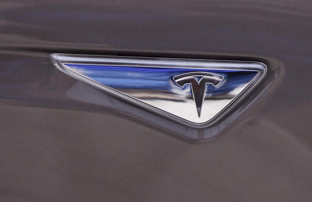 FILE - This April 7, 2015 file photo shows the Tesla logo on the new Tesla Model S 70D during a test drive in Detroit. (AP Photo/Carlos Osorio, File)