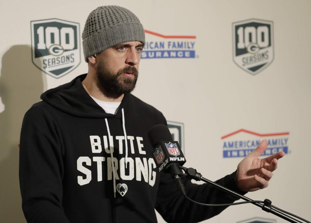 Green Bay Packers quarterback Aaron Rodgers wears a sweatshirt that reads 'Butte Strong' in support of the victims of the Camp Fire in Butte County, Calif., as he talks to reporters following the Packers' NFL football game against the Seattle Seahawks, Thursday, Nov. 15, 2018, in Seattle. The Seahawks won 27-24. (AP Photo/Stephen Brashear)