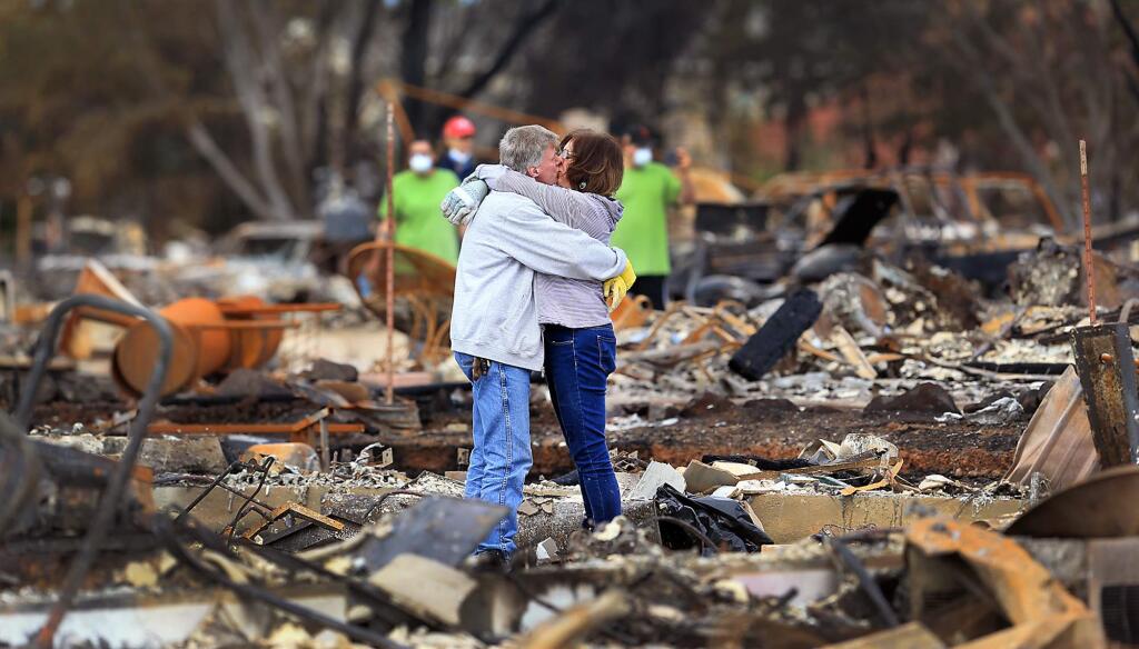 In this Oct. 20, 2017, file photo, Gordon Easter and fiancee Gail Hale embrace as they return to their home on Hopper Lane in Coffey Park in Santa Rosa. Northern California residents who fled a wildfire in the dead of night with only minutes to spare returned to their neighborhoods for the first time in nearly two weeks to see if anything was standing. (Kent Porter/The Press Democrat via AP, File)