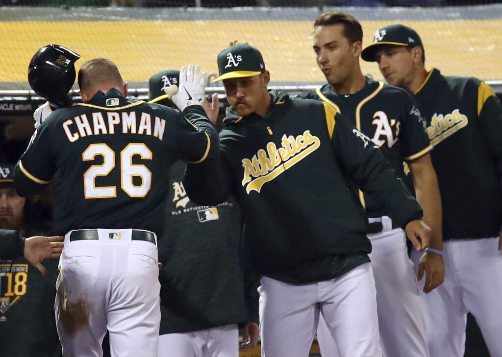 Oakland Athletics' Matt Chapman (26) is congratulated after scoring against the Texas Rangers during the fourth inning of a baseball game Wednesday, April 4, 2018, in Oakland, Calif. (AP Photo/Ben Margot)