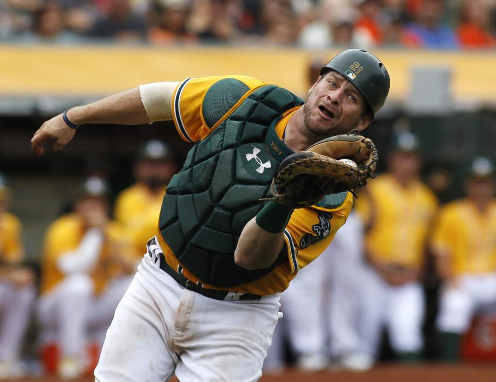 Oakland Athletics' Stephen Vogt catches a foul ball during the seventh inning of a baseball game against the San Francisco Giants, Sunday, Sept. 27, 2015, in Oakland, Calif. (AP Photo/George Nikitin)