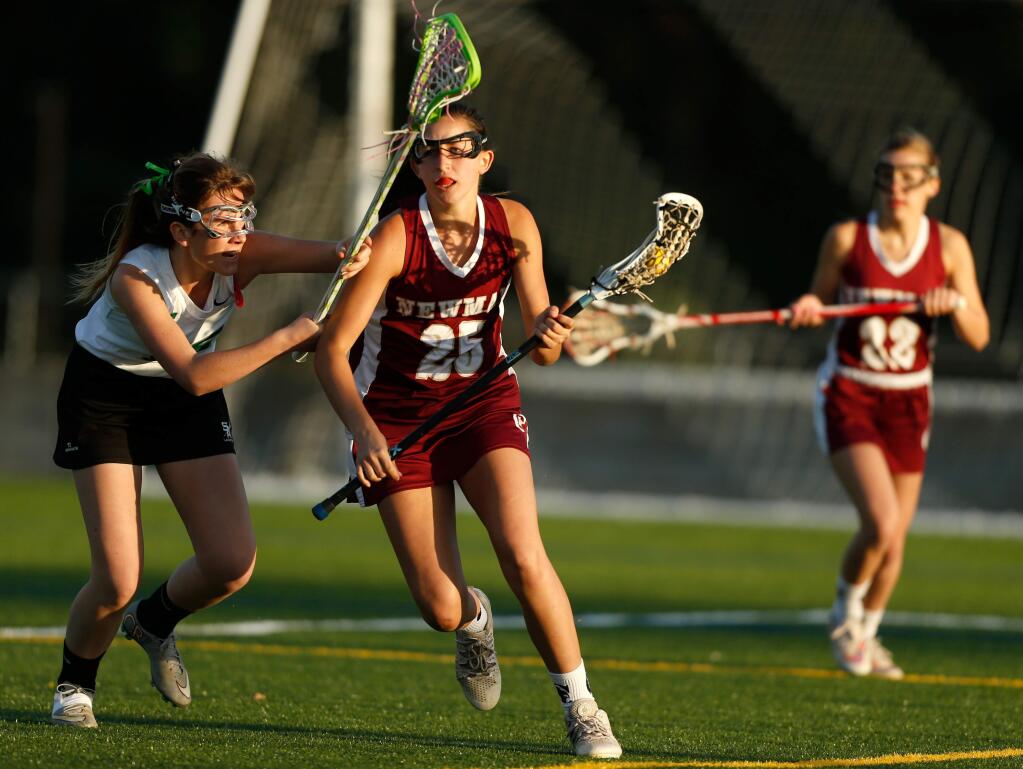 Cardinal Newman's Kasey Braun (25) carries the ball while defended by Sonoma Academy's Reilly Dwight (15), left, during a girls varsity lacrosse game between Cardinal Newman High School and Sonoma Academy in Santa Rosa, California, on Friday, April 29, 2016. (Alvin Jornada / The Press Democrat)