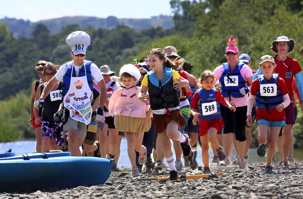 Families race to their kayaks for the start of the double kayak division of The Great Russian River Race at Rio Lindo Beach on Saturday. (JOHN BURGESS / The Press Democrat)