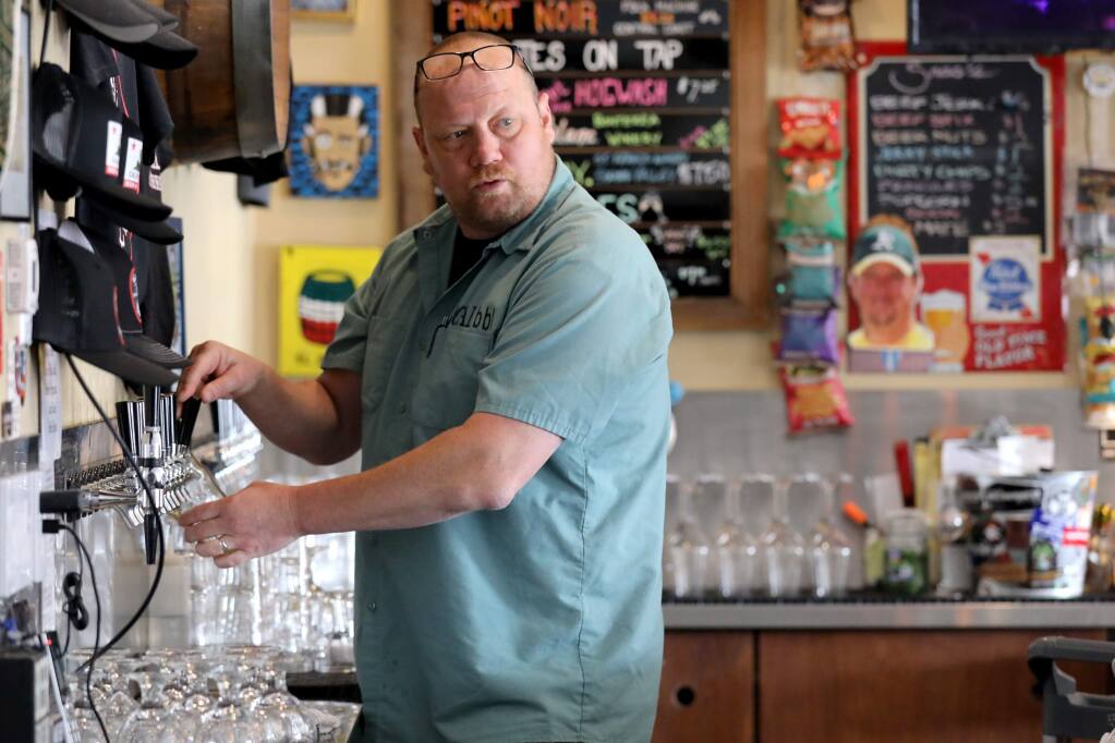 Drew Ferrante, owner of Local Barrel, pours a drink for a customer in Santa Rosa on Monday, March 16, 2020. (Beth Schanker / The Press Democrat)