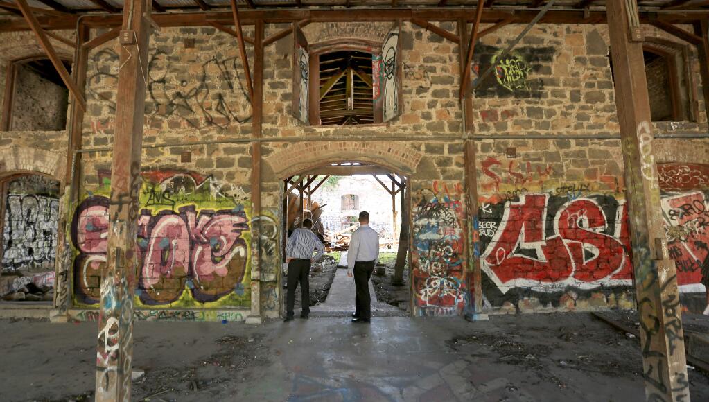 At the old Fountain Grove Winery, Wednesday April 15, 2015, Medtronic's Joe McGrath, left and Eric Kunz tour the structures which are in decay and covered with graffiti. (Kent Porter / Press Democrat) 2015