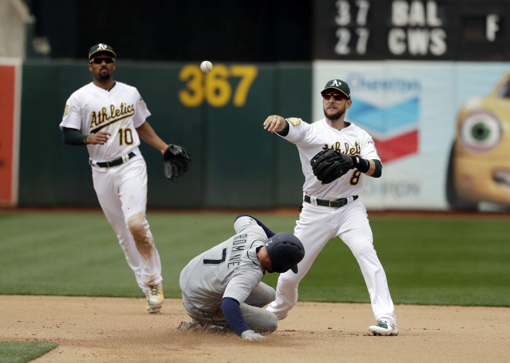 Oakland Athletics second baseman Jed Lowrie, right, completes a double play over the Seattle Mariners' Andrew Romine after a ground ball from David Freitas during the seventh inning Thursday, May 24, 2018, in Oakland. (AP Photo/Marcio Jose Sanchez)