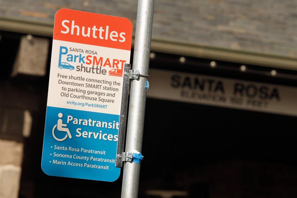 A sign for the ParkSMART shuttle and Paratransit Services marks the shuttle stop outside the California Welcome Center at Railroad Square in Santa Rosa, California, on Wednesday, November 28, 2018. (Alvin Jornada / The Press Democrat)