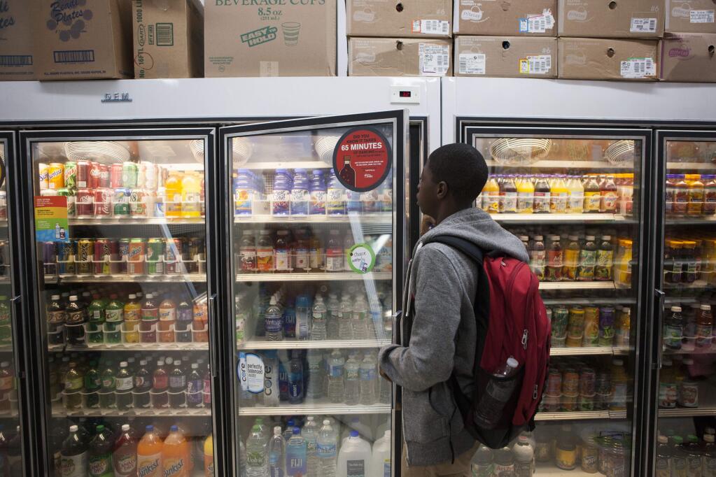 FILE - A teen grabs a flavored water beverage at a corner store in Philadelphia, Sept. 22, 2015. The sugar industry paid scientists in the 1960s to downplay the link between sugar and heart disease and promote saturated fat as the culprit instead, historical documents released in September 2016 show. (Jessica Kourkounis/The New York Times)