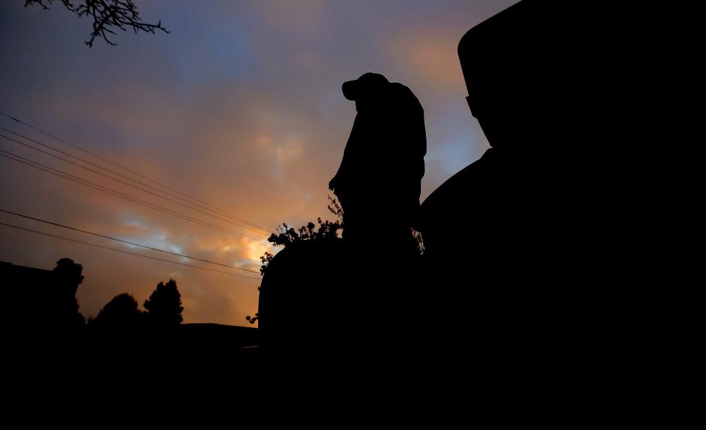 A cold sunrise greets a homeless man, Friday Nov. 28, 2014 as he waits for food and clothing during a weekly Catholic Charities sponsored giveaway at the Homeless Center in Santa Rosa on Morgan Street. (Kent Porter / Press Democrat) 2014