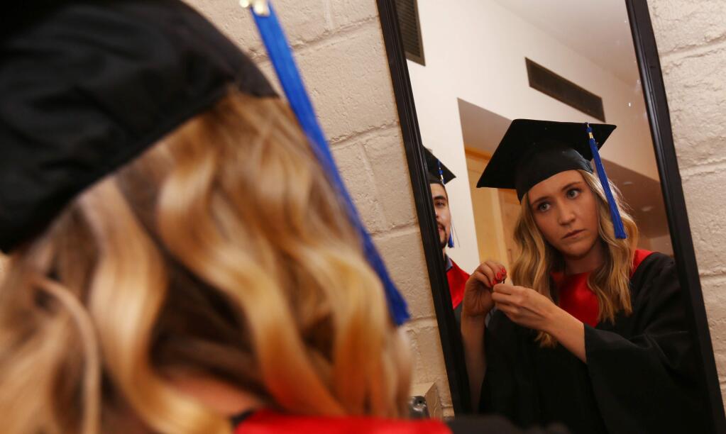 Graduate Elizabeth Buckley of Santa Rosa, looks in the mirror prior to the Empire College commencement at Luther Burbank Center for the Arts in Santa Rosa, Calif., on Thursday, June 14, 2017. (Photo by Darryl Bush / For The Press Democrat)