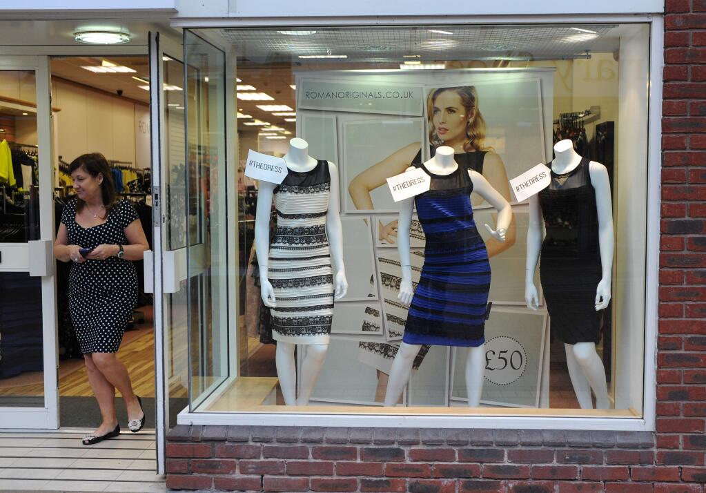 A blue two tone dress is seen in a shop window display alongside differently colored variants of the same design, at a shop in Lichfield, England, Friday, Feb. 27 2015. Friends and co-workers worldwide are debating the true hues of a royal blue dress with black lace that, to many an eye, transforms in one photograph into gold and white. Optometry experts are calling the photo a one-in-a-million shot that perfectly captures how people's brains perceive color and process contrast in dramatically different ways. (AP Photo/Rui Vieira)