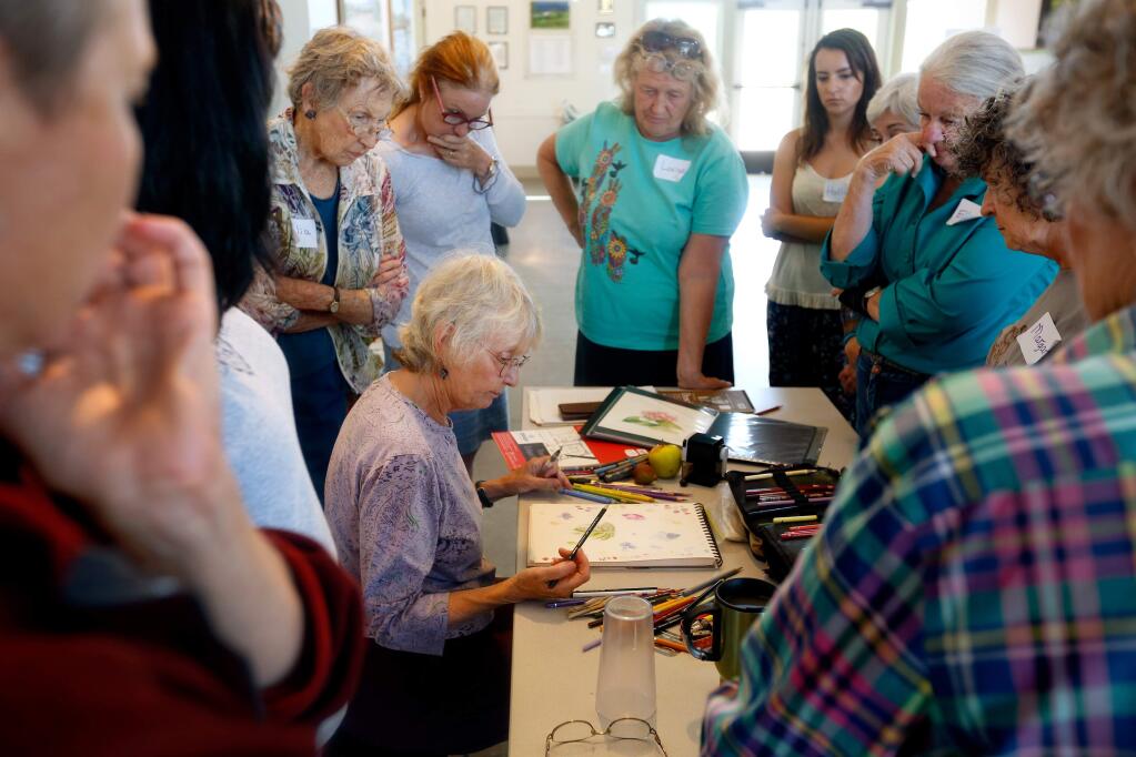 Botanical illustrator Nina Antze, seated, demonstrates working with watercolor pencils during her Drawing Summer Fruits class at Laguna Environmental Center in Santa Rosa, California on Saturday, August 22, 2015.