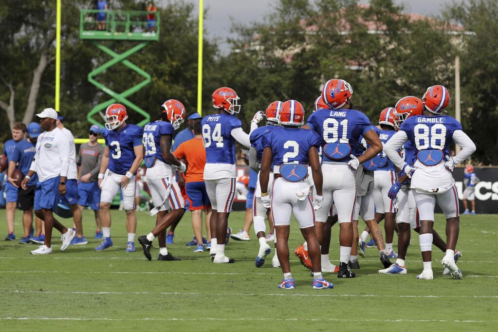 A group of Florida Gators players gather on the field for an NCAA college football practice session on Thursday, Dec. 26, 2019, in Miami Shores, Fla. Florida plays Virginia in the Orange Bowl on Dec. 30. (AP Photo/Mario Houben)
