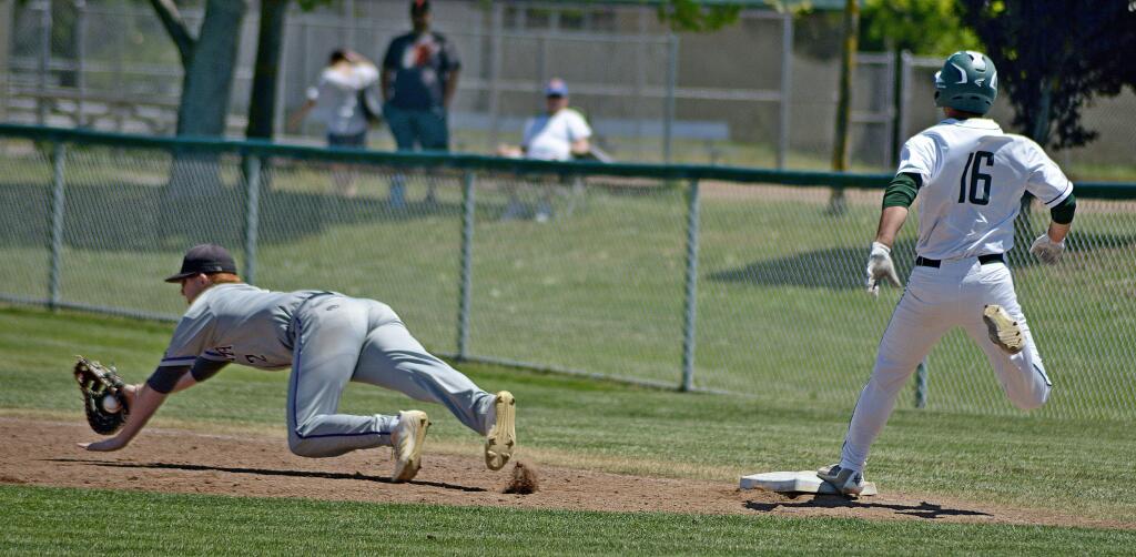 SUMNER FOWLER/FOR THE ARGUS-COURIERPetaluma first baseman Sam Brown dives to snare a wild throw as Casa Grande's Ibai Guadron arrives at the bag safely.