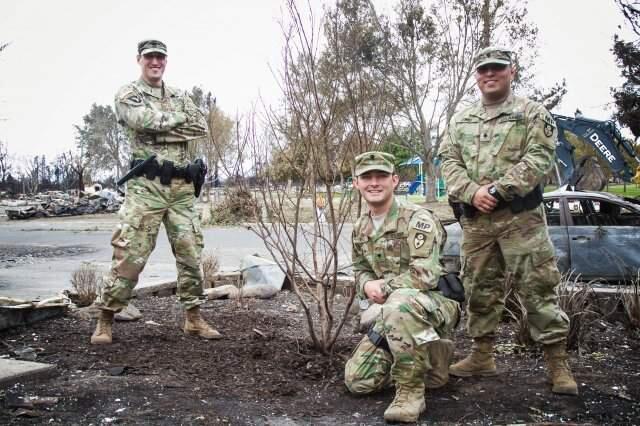 The California Army National Guard MPs and the tree in Coffey Park they promised to water, and did. (Photo by Sgt. 1st Class Benjamin Cossel)