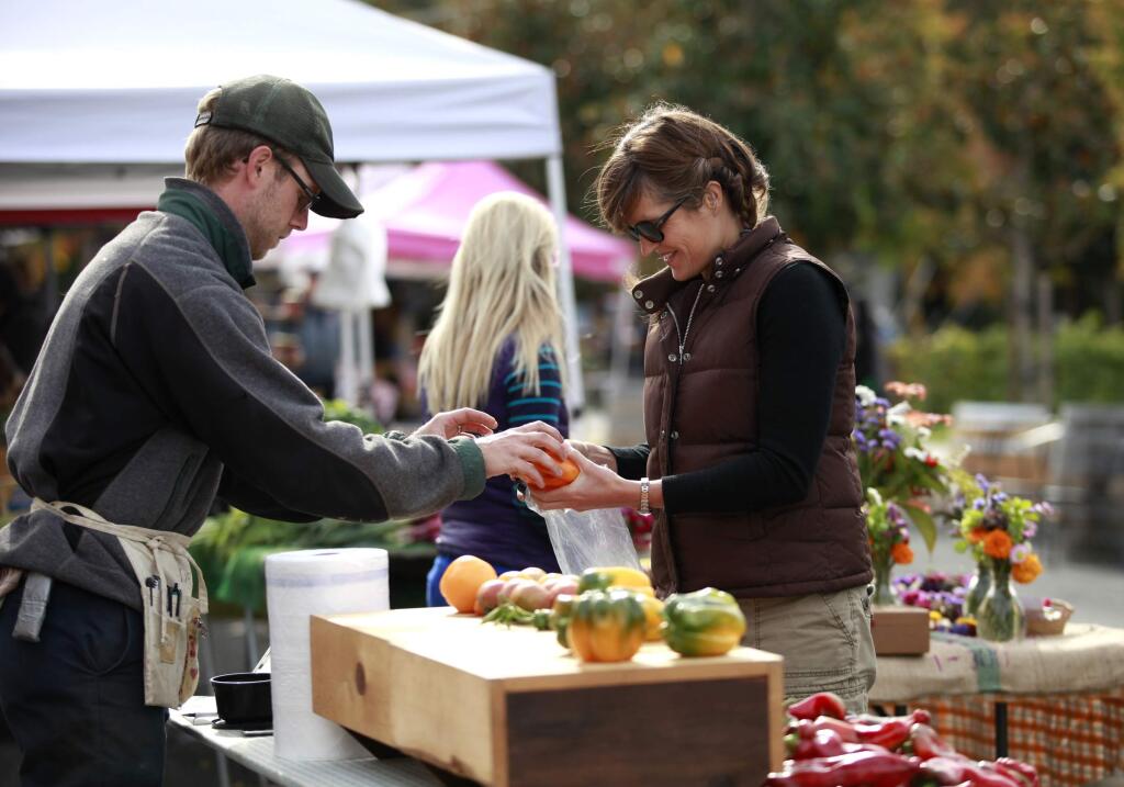 Tara Scott buys peppers from Ian Healy of Handlebar Farm during The West End Farmers Market in Santa Rosa. (BETH SCHLANKER/ The Press Democrat, file 2013)