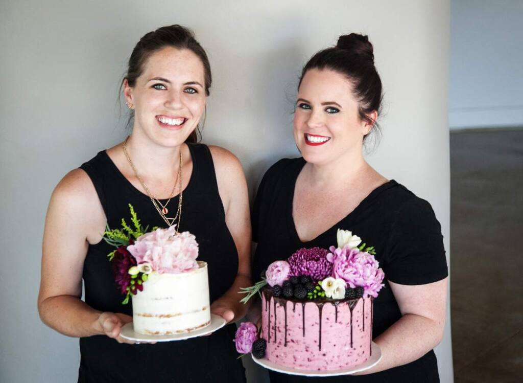 Holly Knipe (L) and Maddie Smith (R) hold cakes. (Photo by Brie Rose Photography)