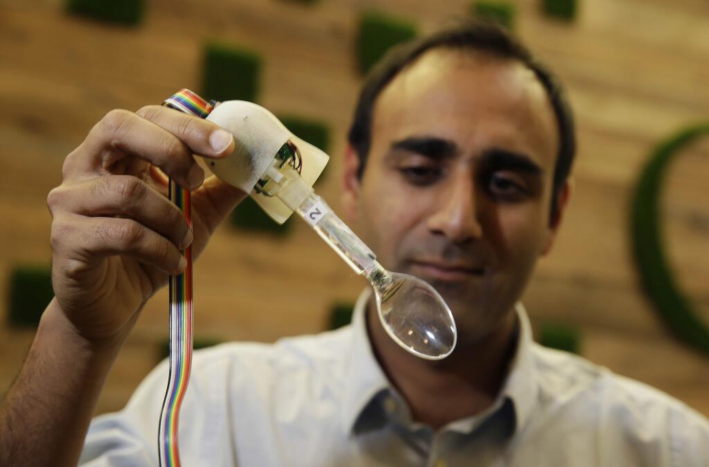 In this photo taken Friday, Nov. 21, 2014, Anupam Pathak, a senior hardware engineer at Google, shows off the prototype of the Liftware Spoon he developed that helps people eat without spilling in Mountain View, Calif. Just in time for the holidays, Google is throwing its money, brain power and technology at the humble spoon. Not surprisingly, the company that has brought the driverless car and Internet glasses is bringing a unique improvement to the utensils. Built with hundreds of algorithms, these specially designed spoons make it much easier for people with tremors and Parkinsons Disease to eat without spilling. The spoons sense a shaking hand and make instant adjustments to stay balanced. (AP Photo/Eric Risberg)